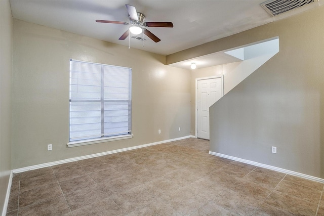 empty room with a ceiling fan, visible vents, and baseboards