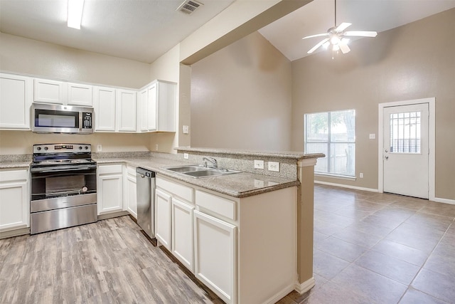 kitchen with stainless steel appliances, visible vents, white cabinets, a sink, and a peninsula