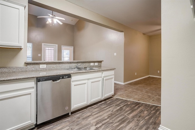 kitchen with stainless steel dishwasher, white cabinets, a sink, wood finished floors, and a peninsula