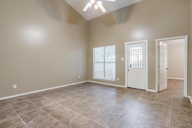 empty room featuring baseboards, high vaulted ceiling, a ceiling fan, and tile patterned floors