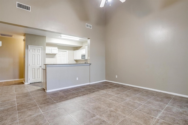 unfurnished room with light tile patterned floors, visible vents, and baseboards