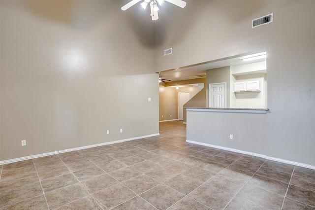 spare room with baseboards, visible vents, and a ceiling fan