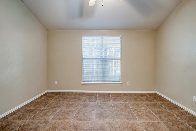 spare room with tile patterned flooring, ceiling fan, and baseboards