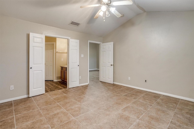 unfurnished bedroom featuring baseboards, visible vents, connected bathroom, vaulted ceiling, and light tile patterned flooring