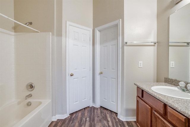 full bath with shower / washtub combination, vanity, baseboards, and wood finished floors