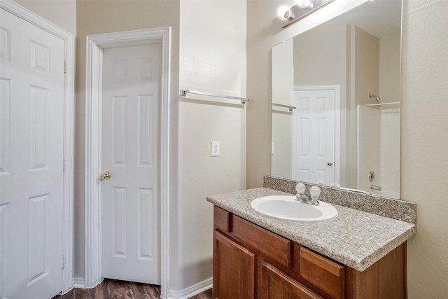 full bathroom with wood finished floors and vanity