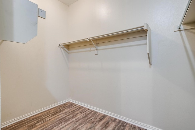 walk in closet with wood finished floors