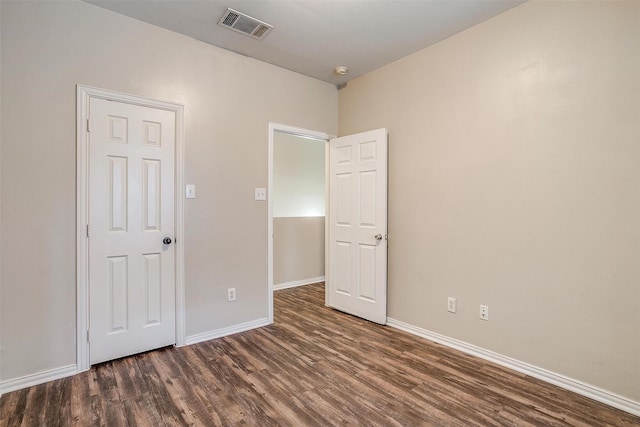 unfurnished bedroom with dark wood-style floors, baseboards, and visible vents