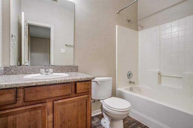 full bath featuring toilet, shower / bathing tub combination, wood finished floors, and vanity