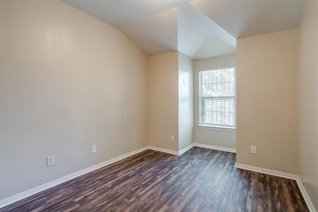 unfurnished room featuring baseboards, vaulted ceiling, and dark wood-type flooring