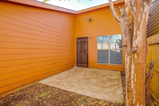 doorway to property featuring a patio area and fence