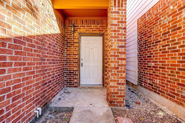 property entrance featuring brick siding