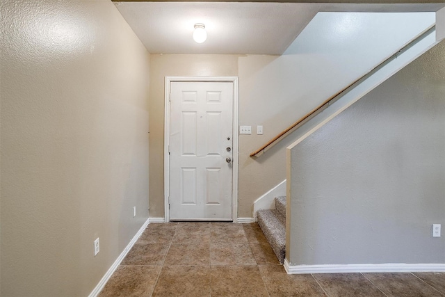 entryway with stairs, tile patterned floors, and baseboards