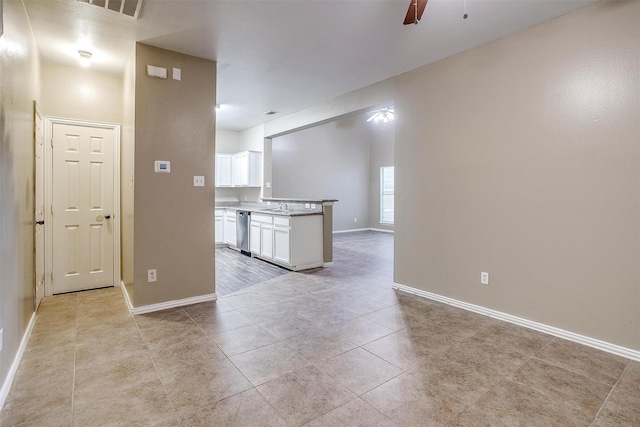 spare room with a sink, baseboards, a ceiling fan, and light tile patterned flooring