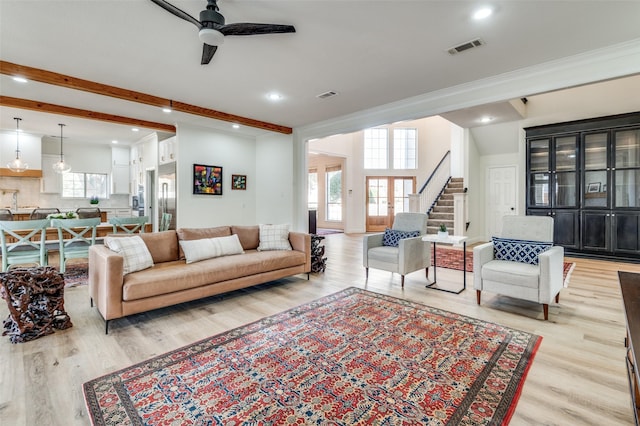 living room with visible vents, beamed ceiling, stairs, and a ceiling fan