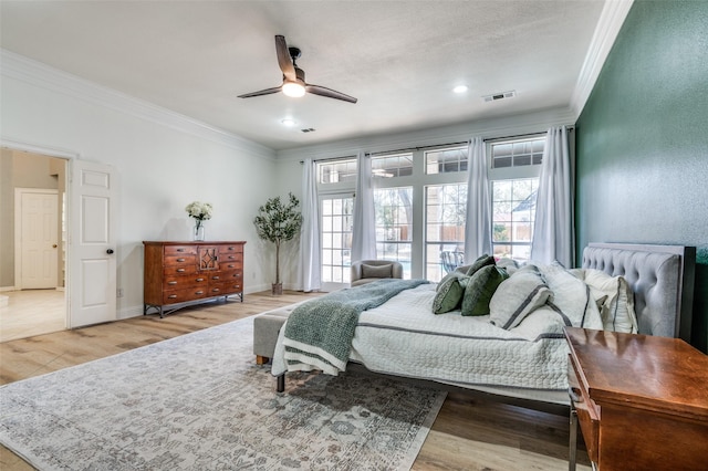 bedroom with visible vents, radiator, crown molding, baseboards, and wood finished floors