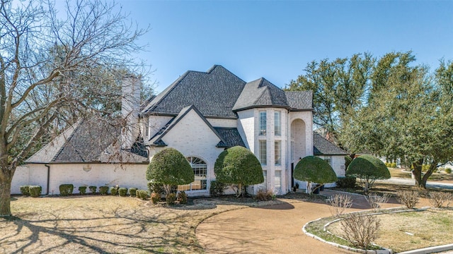 french country style house with brick siding