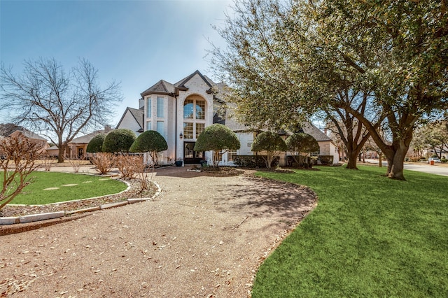 french country inspired facade featuring a front yard