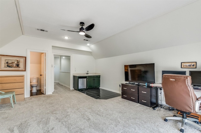 office area featuring visible vents, a ceiling fan, a sink, carpet floors, and vaulted ceiling