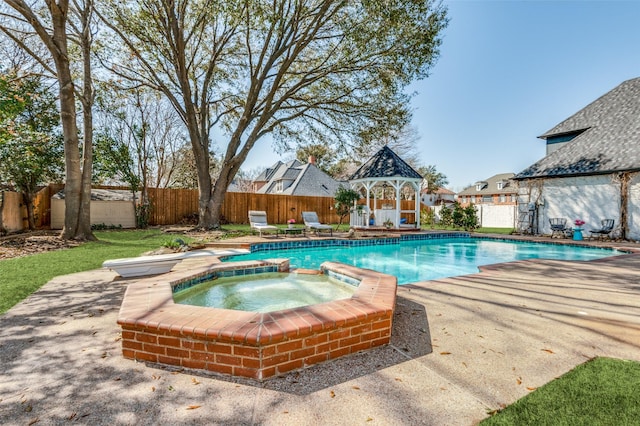 view of swimming pool featuring a gazebo, a fenced backyard, a pool with connected hot tub, and a patio area