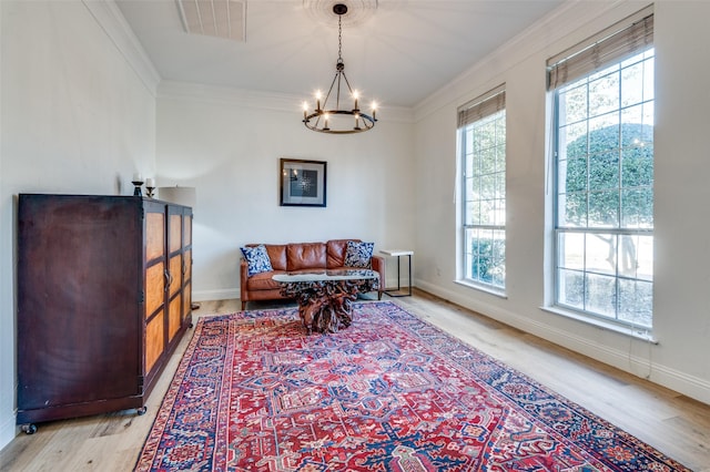 sitting room featuring crown molding, light wood finished floors, baseboards, a notable chandelier, and visible vents