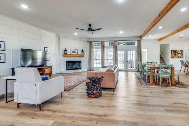 living area with light wood-style floors, crown molding, and ceiling fan