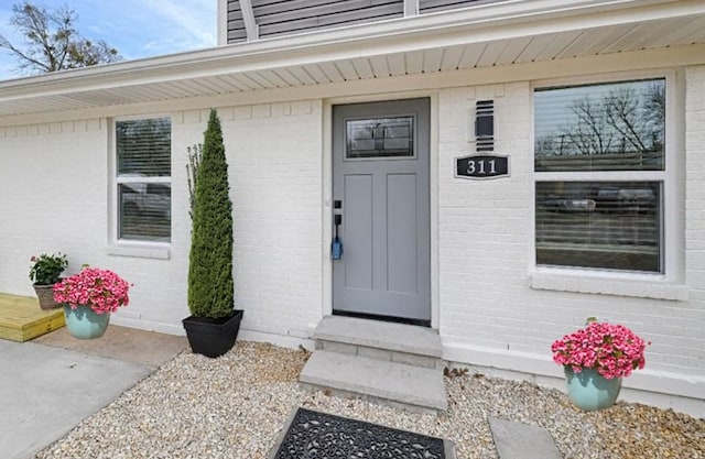 view of exterior entry featuring brick siding