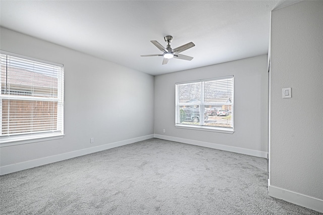 spare room with carpet floors, ceiling fan, and baseboards