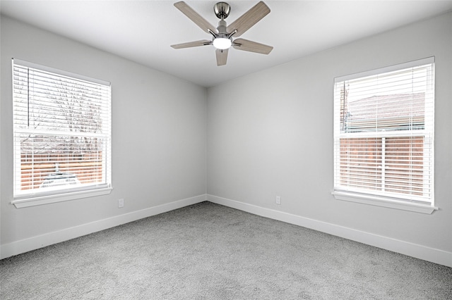 carpeted empty room with ceiling fan and baseboards