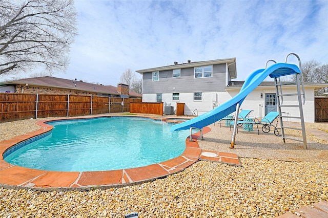 view of pool featuring a patio, a water slide, a fenced backyard, and a fenced in pool