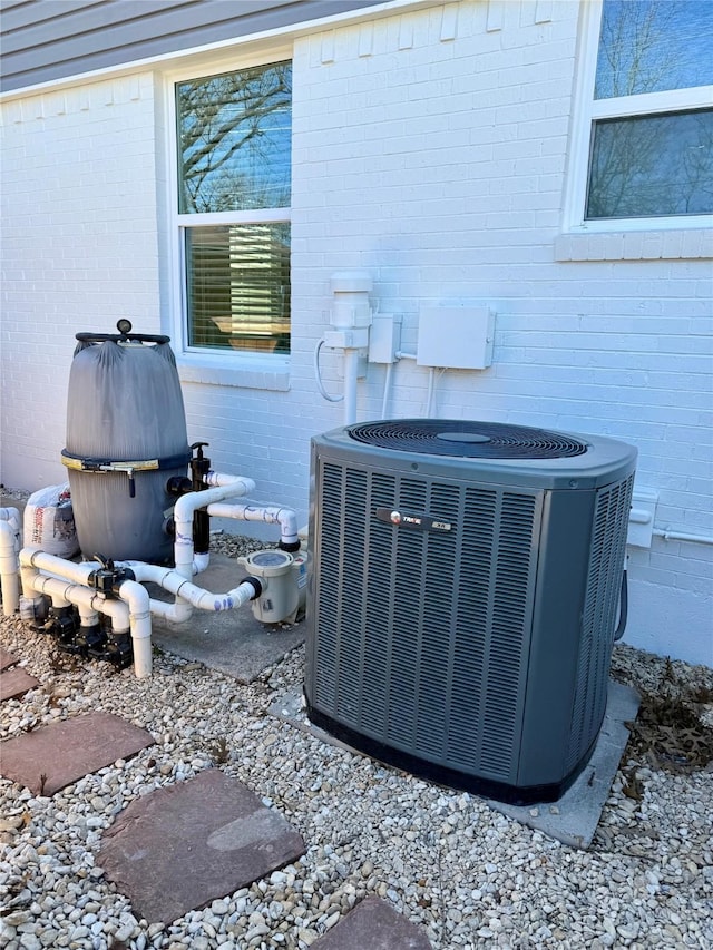 details featuring cooling unit and brick siding