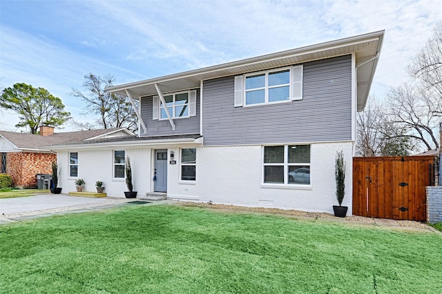 traditional home with crawl space, a gate, fence, a front lawn, and brick siding