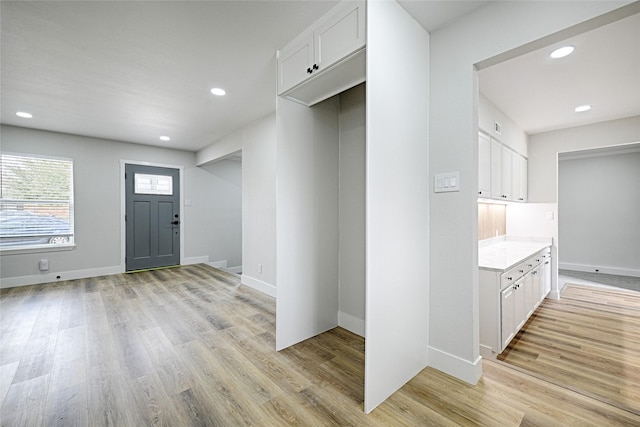 entryway with light wood-type flooring, baseboards, and recessed lighting