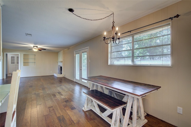 dining space featuring dark wood-type flooring, a wealth of natural light, visible vents, and a fireplace