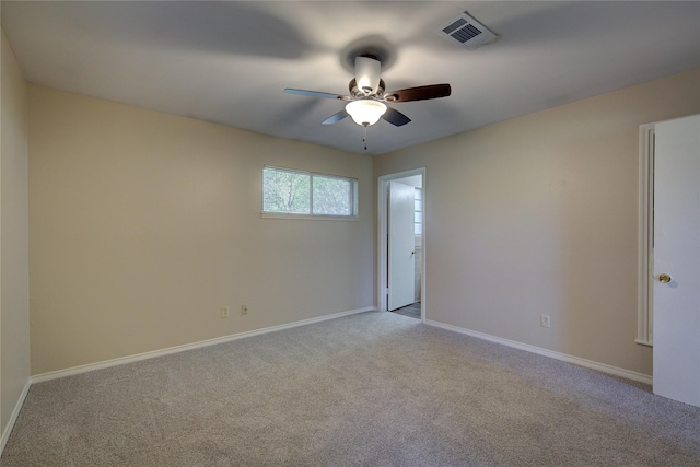 unfurnished room with carpet floors, baseboards, visible vents, and a ceiling fan