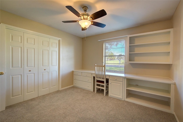 unfurnished office featuring light carpet and ceiling fan