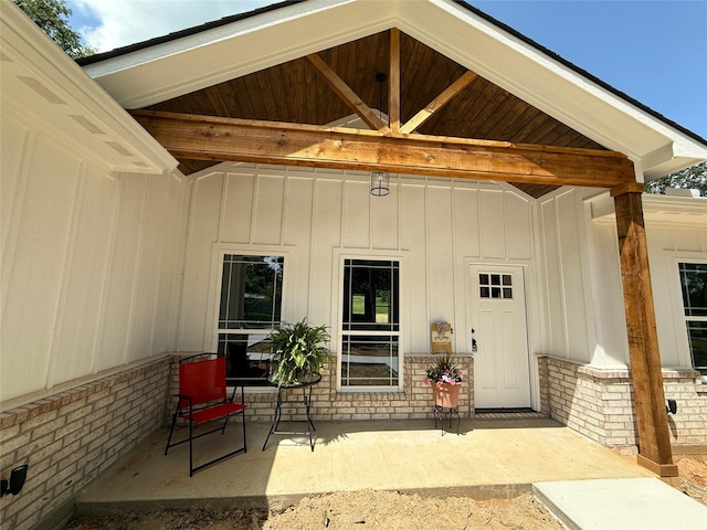 property entrance featuring board and batten siding and a patio