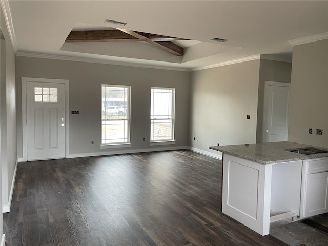 unfurnished living room with dark wood-type flooring, visible vents, crown molding, and baseboards
