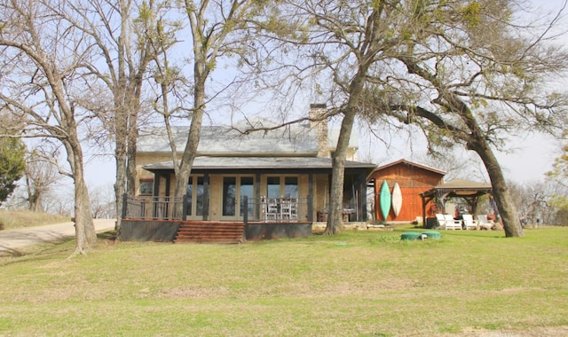 rear view of property featuring a yard and a chimney