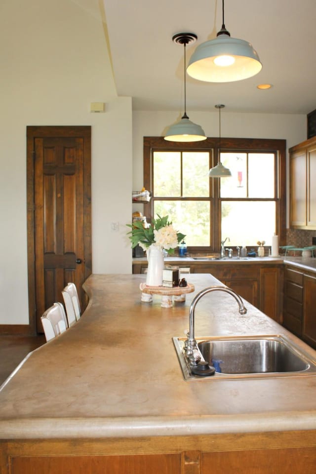 kitchen with light countertops, a sink, decorative light fixtures, and recessed lighting