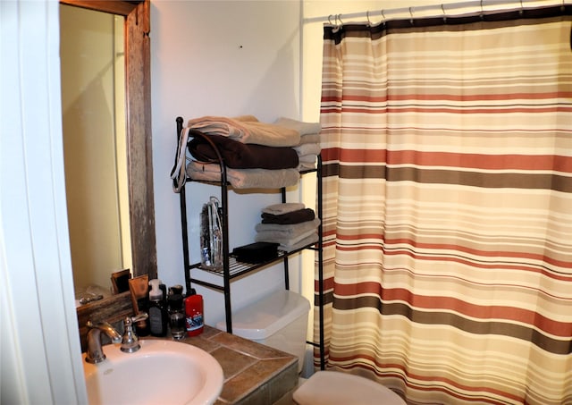 full bathroom with a shower with shower curtain, a sink, and toilet