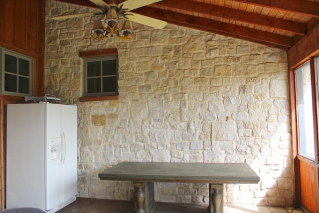 interior space featuring white fridge with ice dispenser, wooden ceiling, ceiling fan, and lofted ceiling with beams