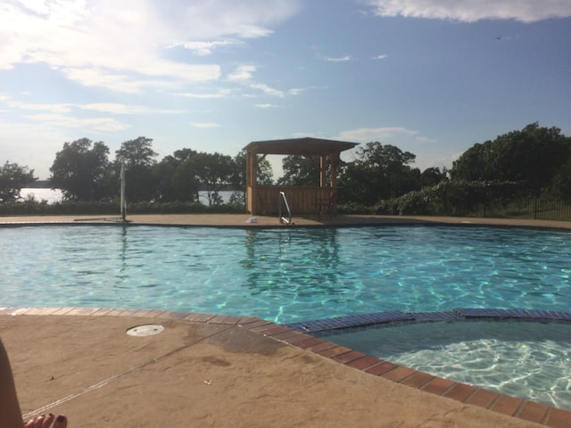 view of swimming pool with a pool with connected hot tub