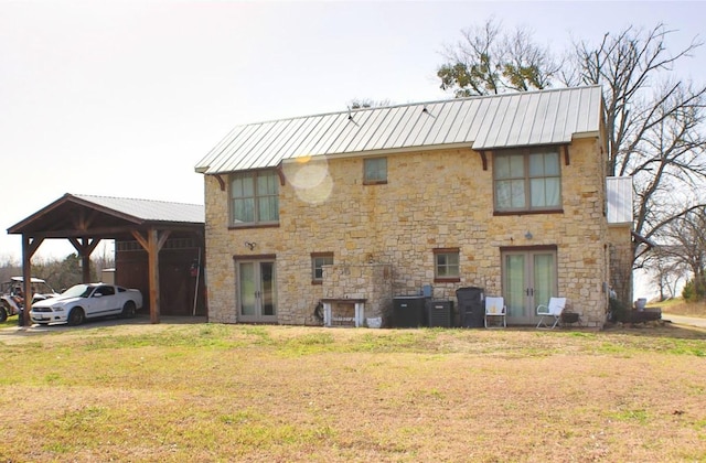 view of front facade featuring a carport, french doors, metal roof, and a front lawn