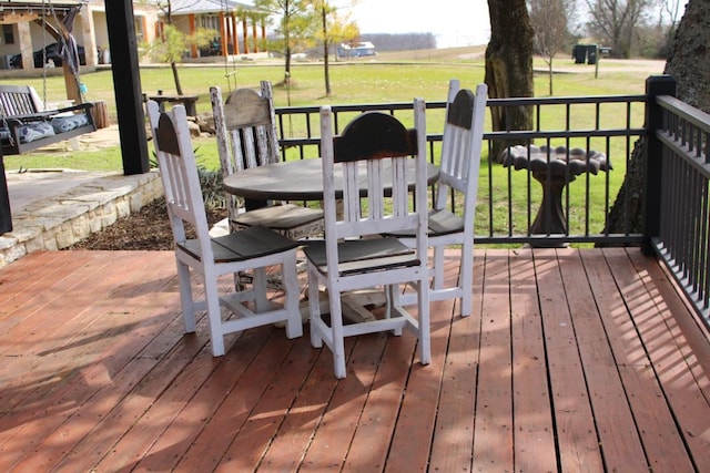 deck featuring outdoor dining space and a yard