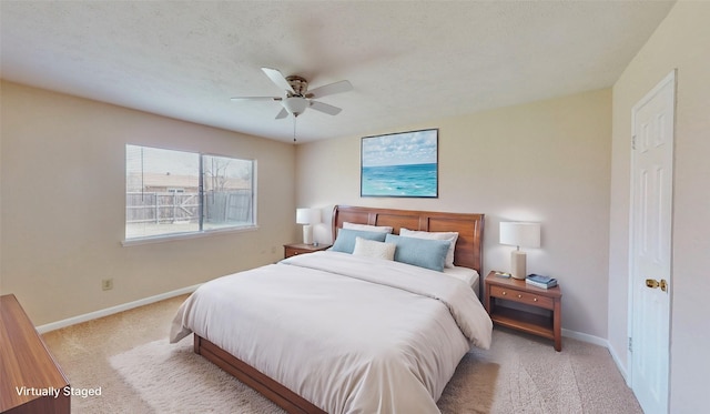 bedroom featuring a ceiling fan, light colored carpet, a textured ceiling, and baseboards