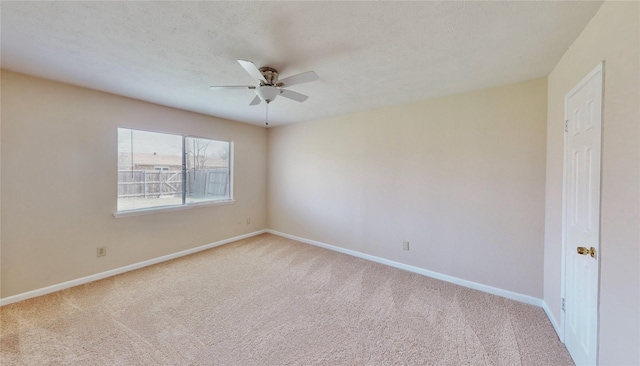 empty room featuring a textured ceiling, ceiling fan, carpet flooring, and baseboards