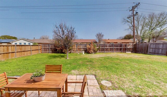 view of yard featuring outdoor dining space and a fenced backyard