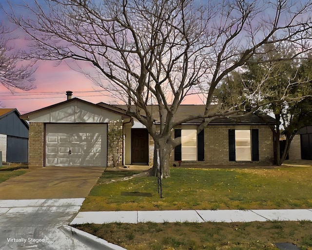 view of front facade featuring a garage, driveway, brick siding, and a front lawn