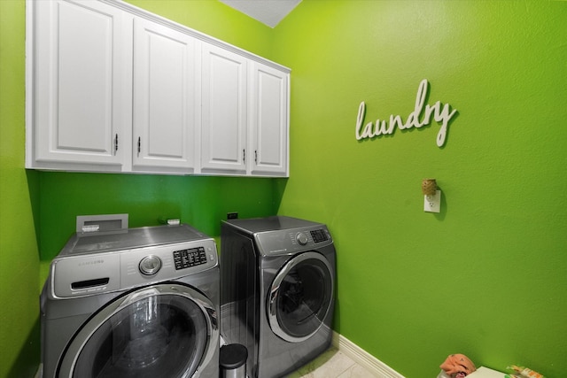 laundry room with cabinet space, tile patterned flooring, baseboards, and washer and dryer